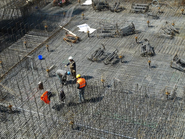 3 workers at big construction site